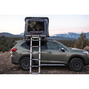 view of ikamper skycamp 3.0 mini on top of an SUV with mountains in the background